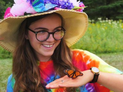 Lady with a butterfly on her hand at the Garden Party Event